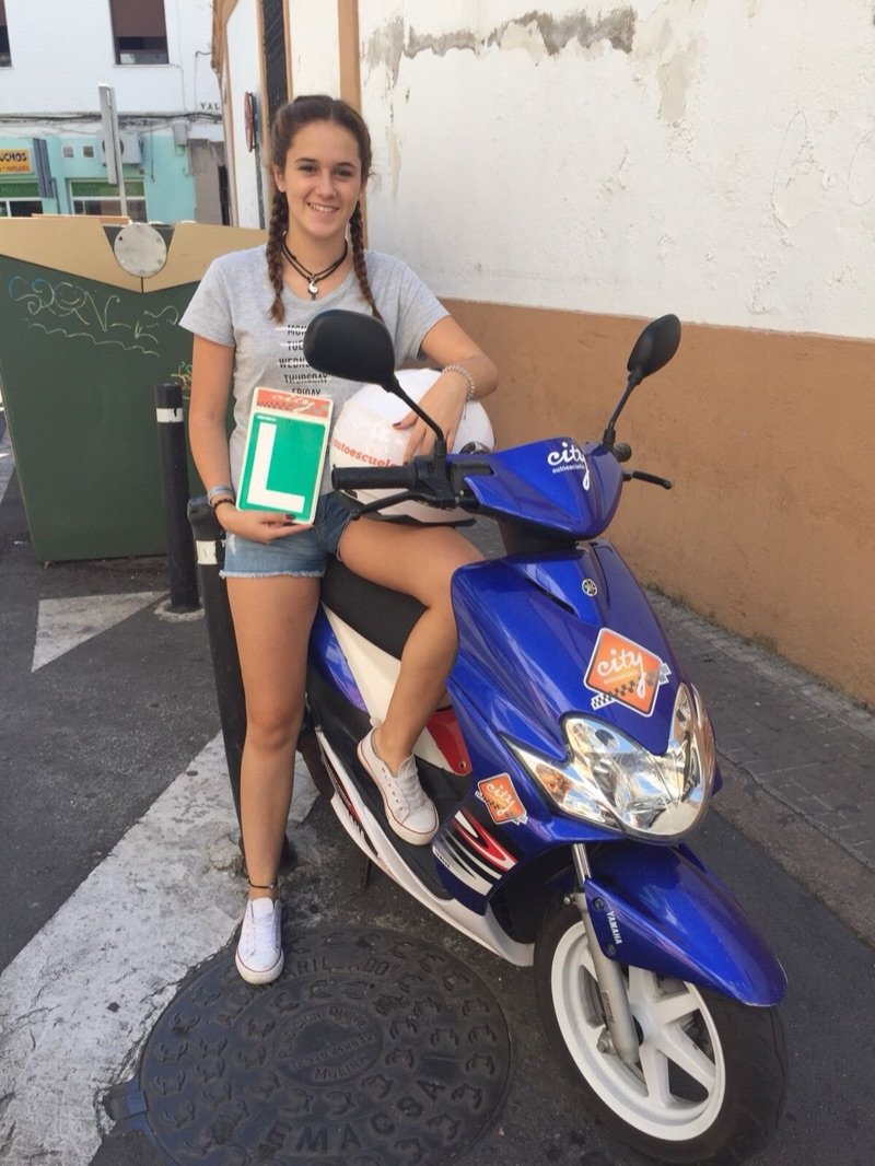 Alumna aprobada de la licencia AM con la placa L junto al ciclomotor Yamaha