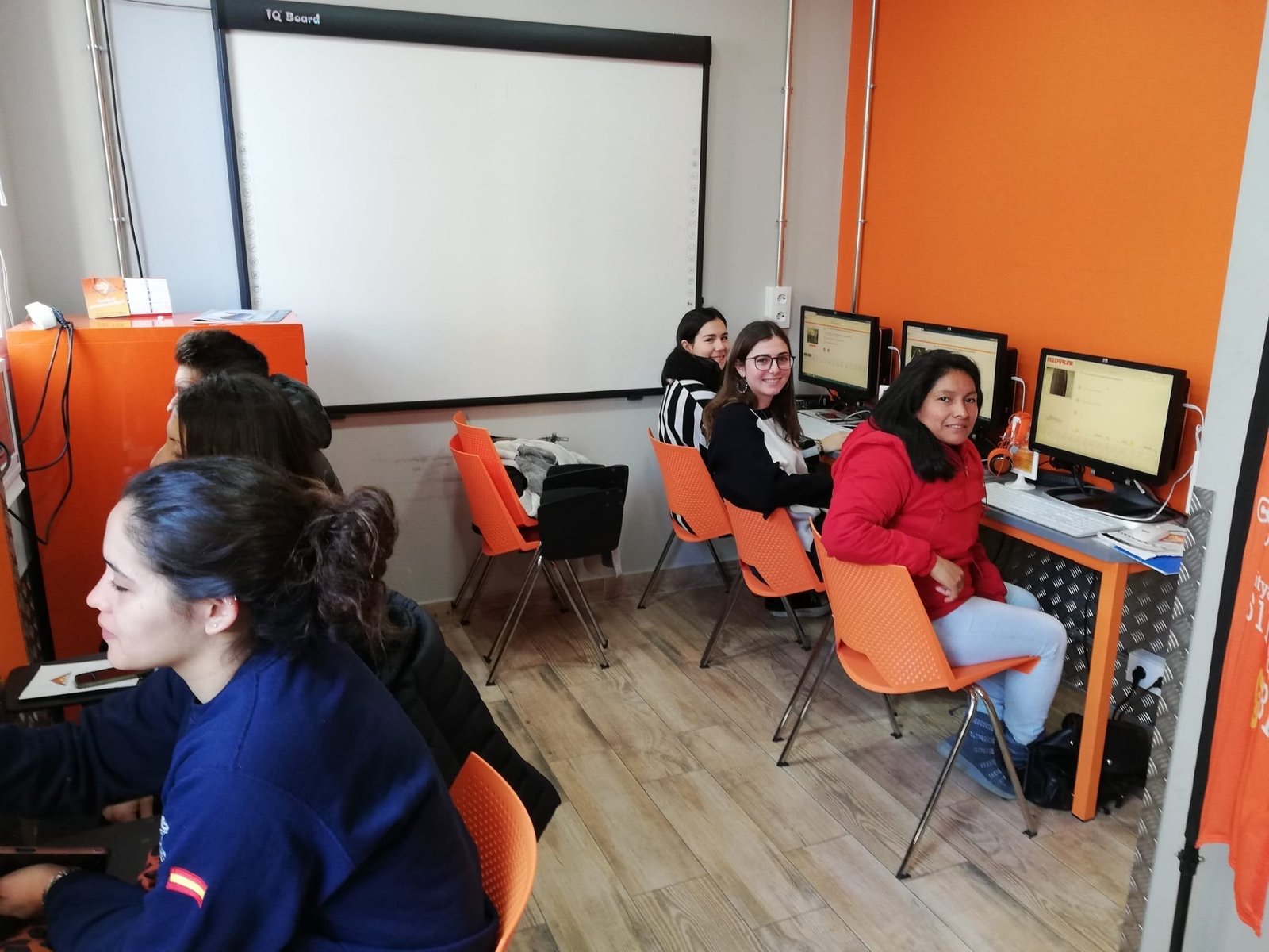 Alumnas sonrientes haciendo tests en el aula de informática de City Autoescuela