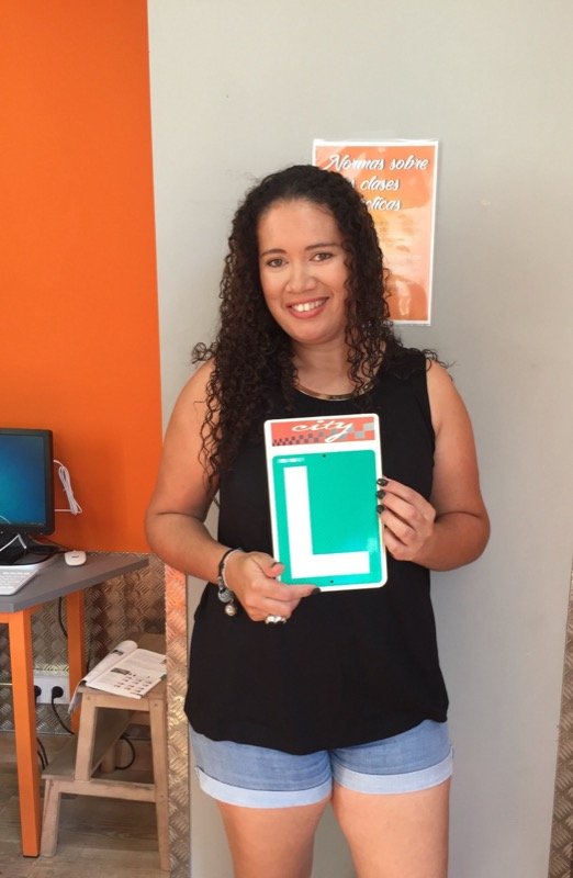 Adriana, alumna de City Autoescuela, sosteniendo la placa L tras aprobar