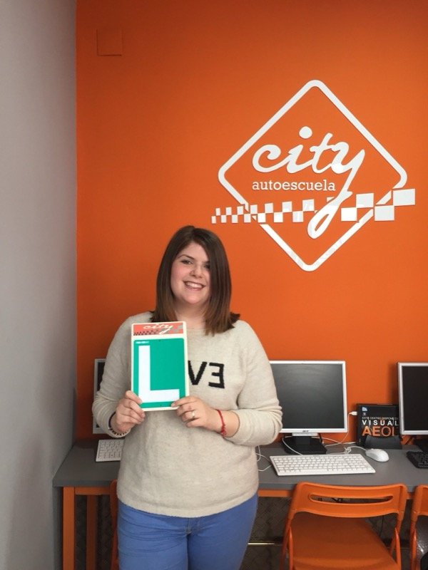 Cristina, alumna de City Autoescuela, con su placa L tras aprobar