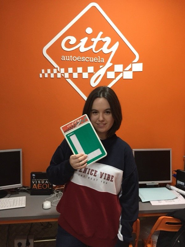 Lourdes, alumna de City Autoescuela, celebrando el aprobado con su placa L