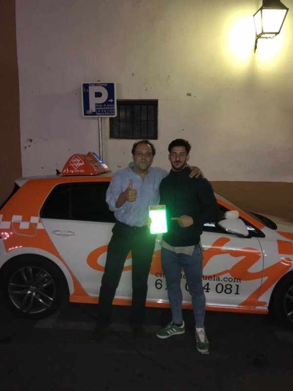 Manu con su profesor junto al Golf de prácticas de City Autoescuela tras aprobar