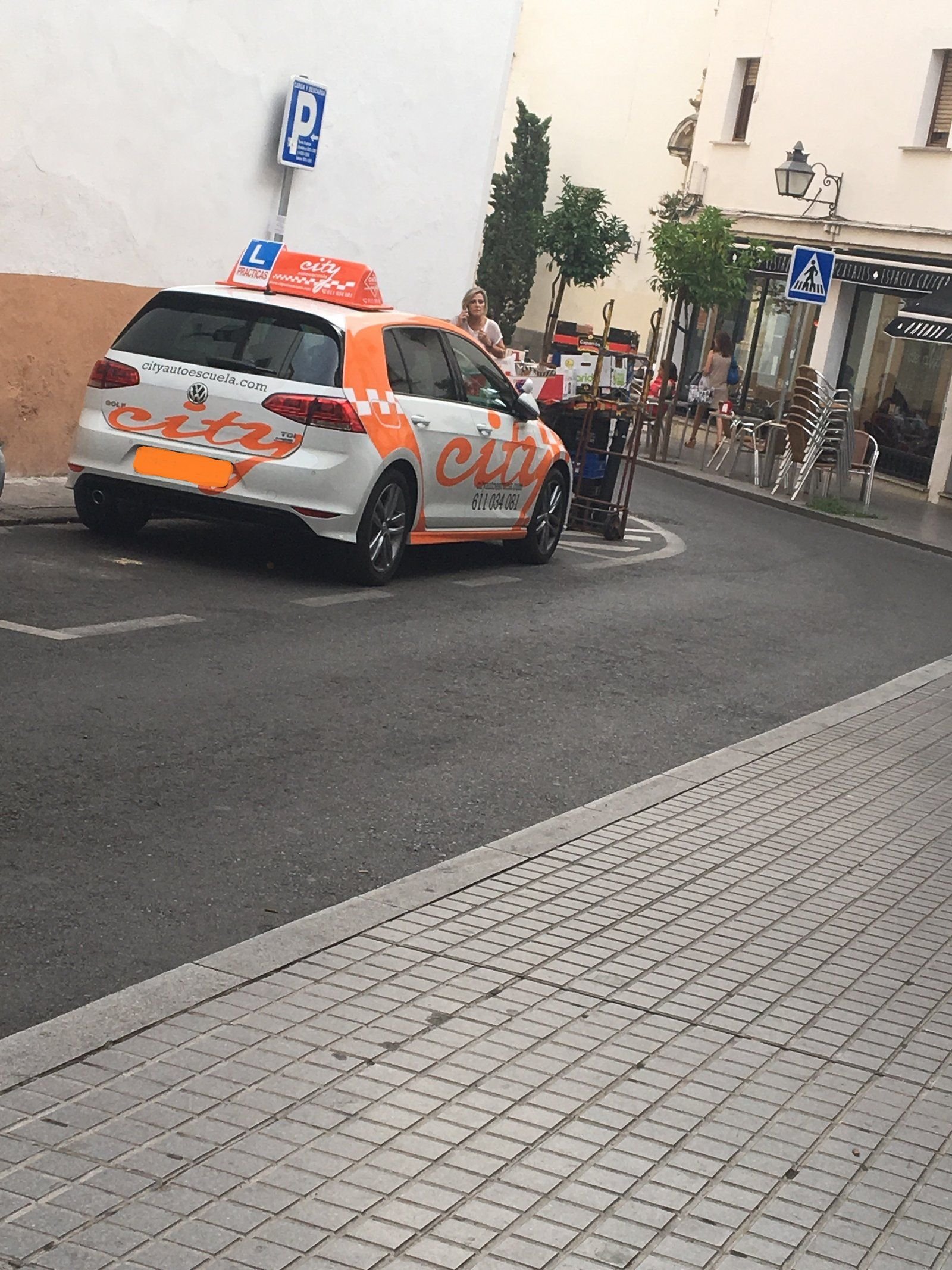 Coche de prácticas de City Autoescuela rotulado, circulando por el centro de Córdoba