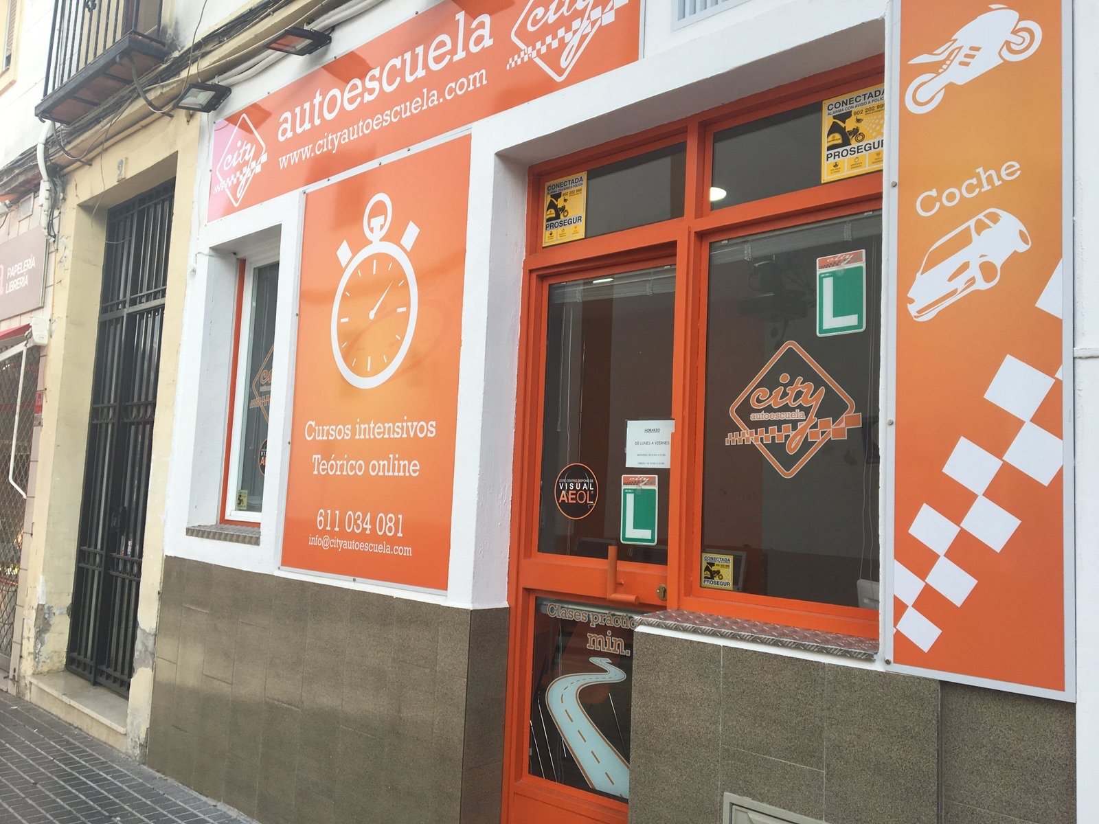 Fachada naranja de City Autoescuela con sus rótulos, en Calle Tesoro, Córdoba