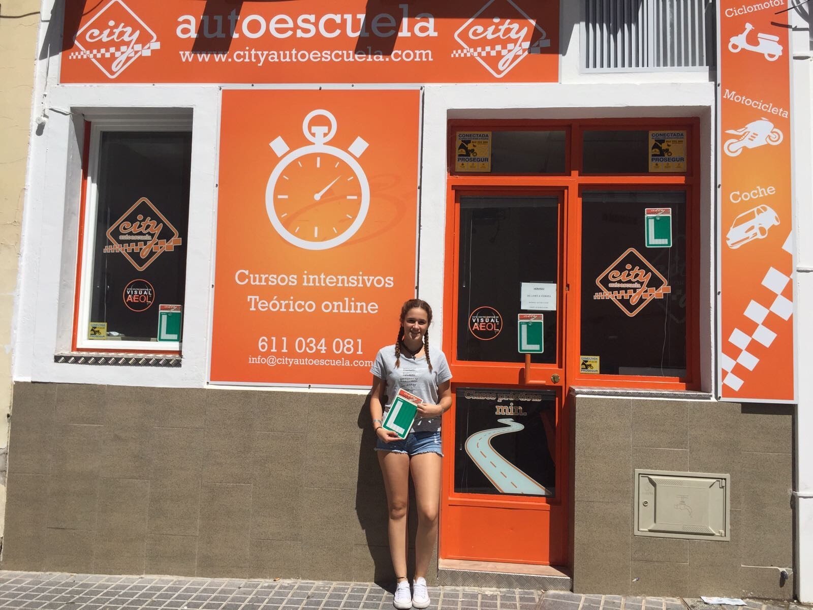 Alumna aprobada con la placa L frente a la fachada de City Autoescuela, en el centro de Córdoba