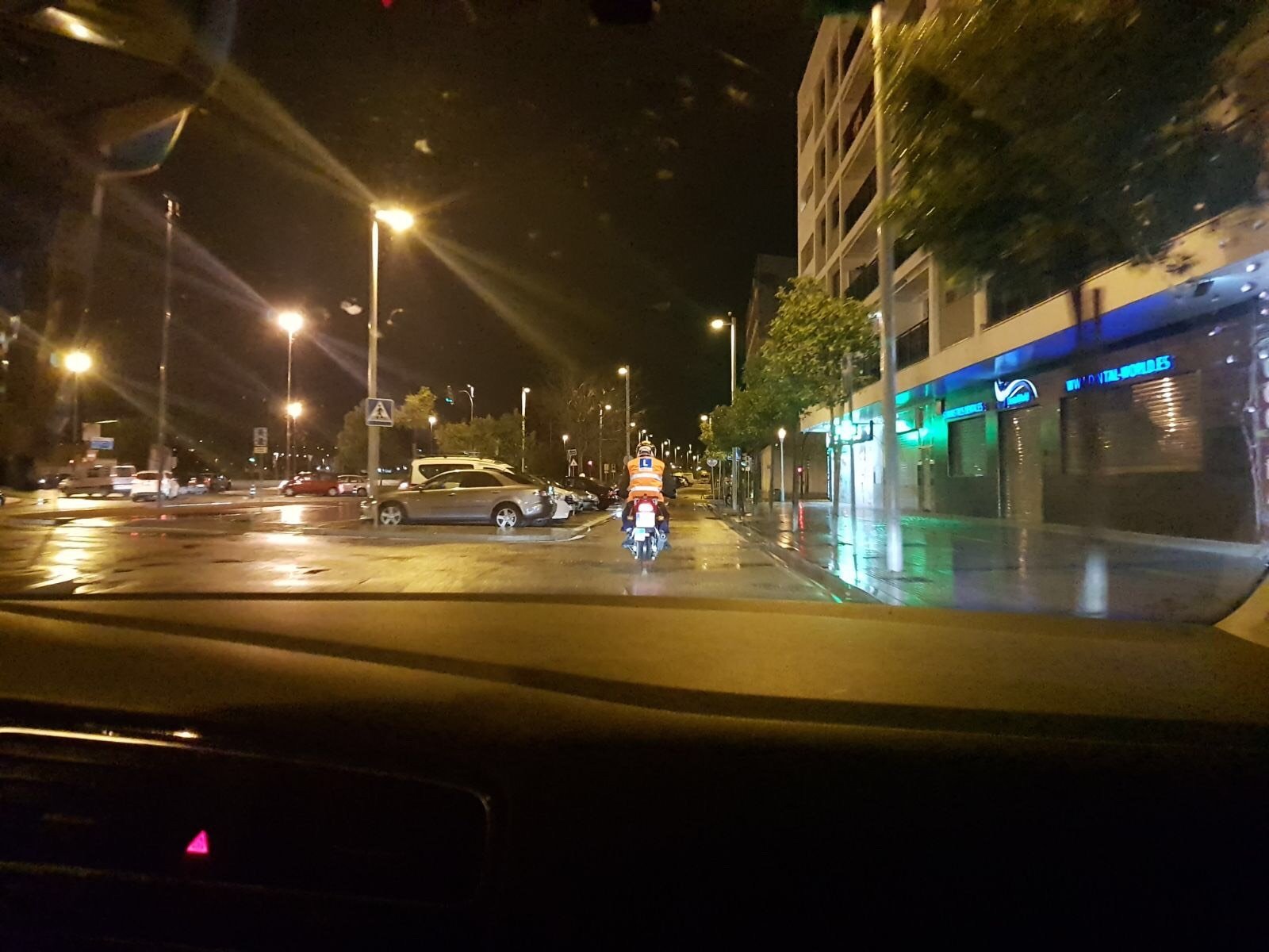 Alumno de moto circulando de noche con lluvia en una práctica del A2 por Córdoba